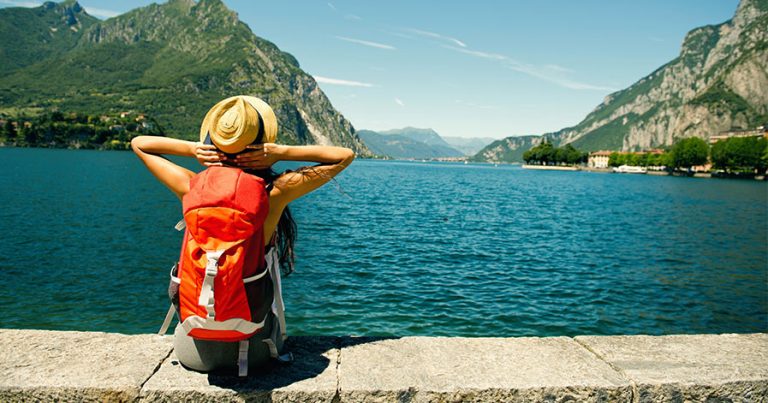 Backpacker sitting beside lake