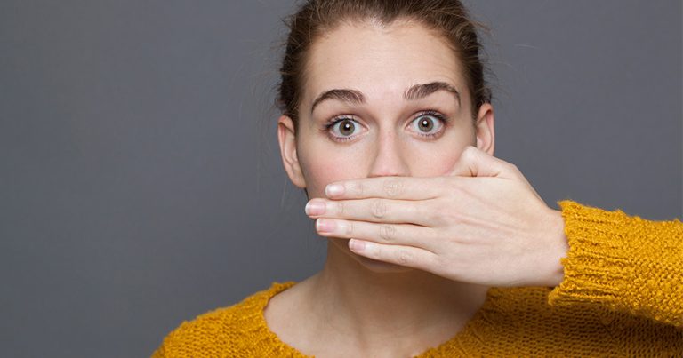 Woman holding hand over her mouth