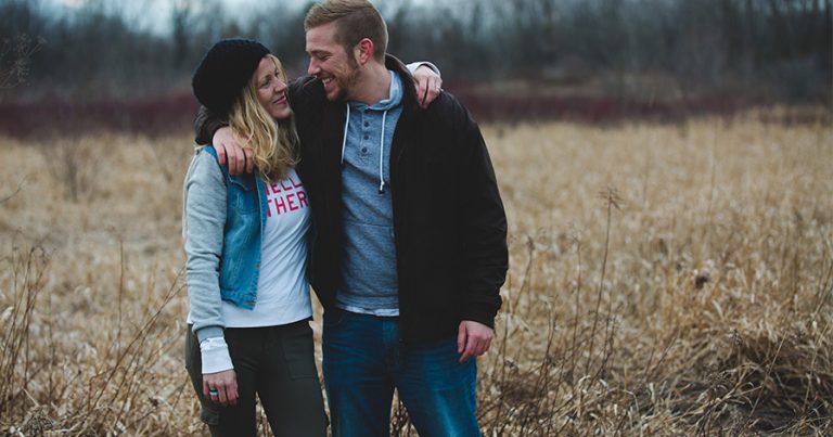 Couple with arms around each other in the fall