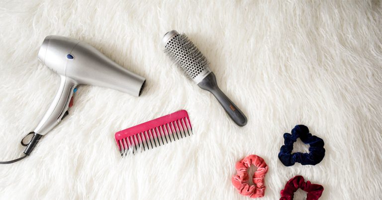 Blow dryer, scrunchies and brushes on carpet