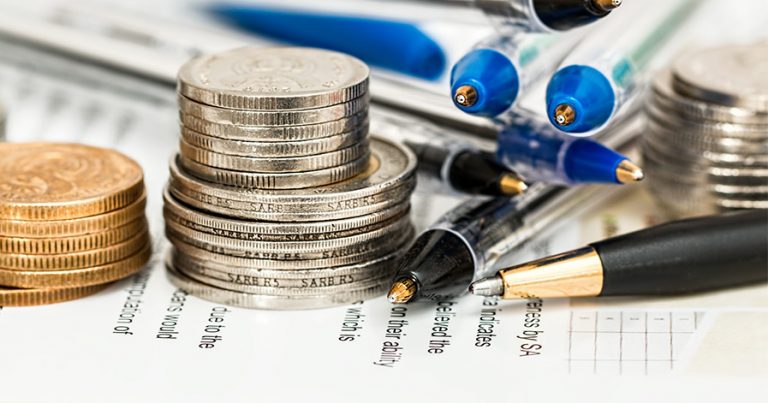 Coins, pens and a budget sheet