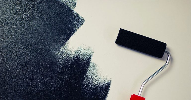 Paint roller painting blue on a white wall