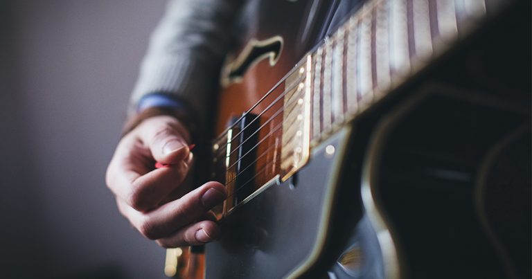 Person strumming on guitar