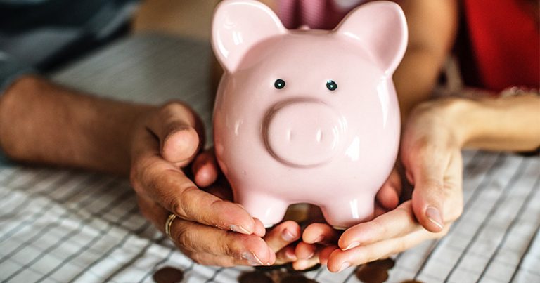 Man and woman holding a piggy bank