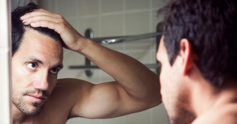 Man looking in mirror at his hair