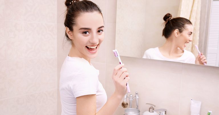 Woman about to brush her teeth
