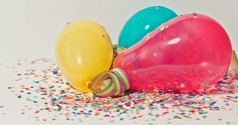Balloons and confetti on a table.