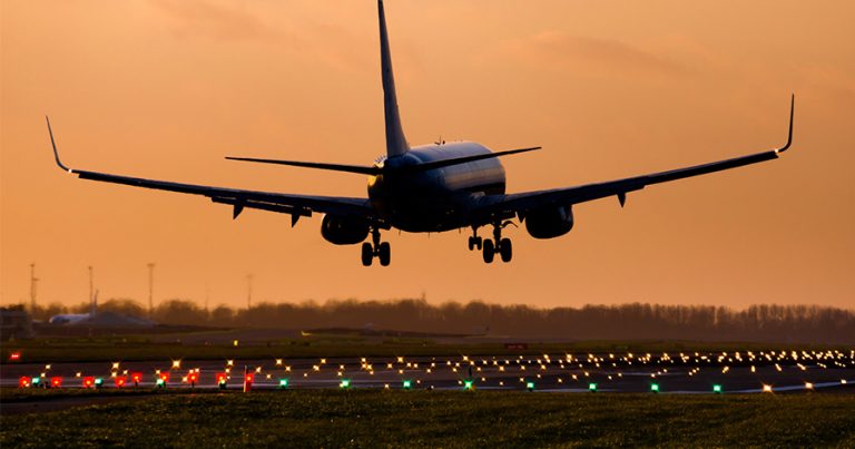Plane taking off into sunset