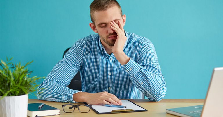 Man looking stressed sitting at a desk