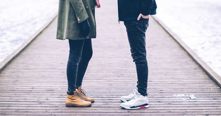 A couple standing on a dock, across from each other