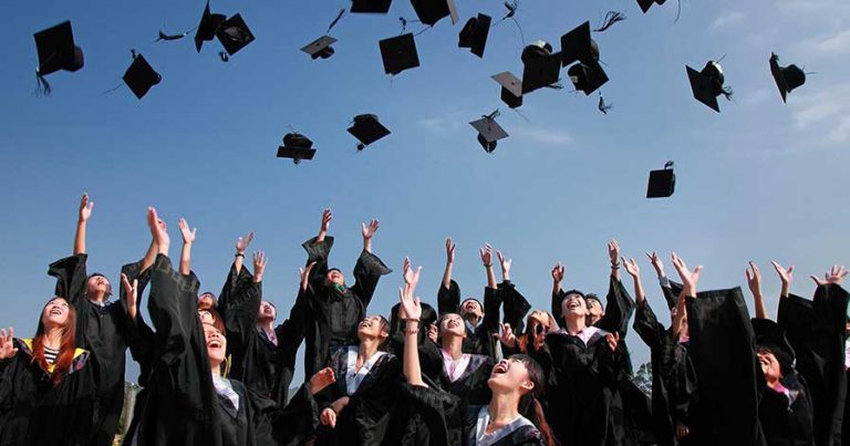 A group of college graduates throwing their caps in the air