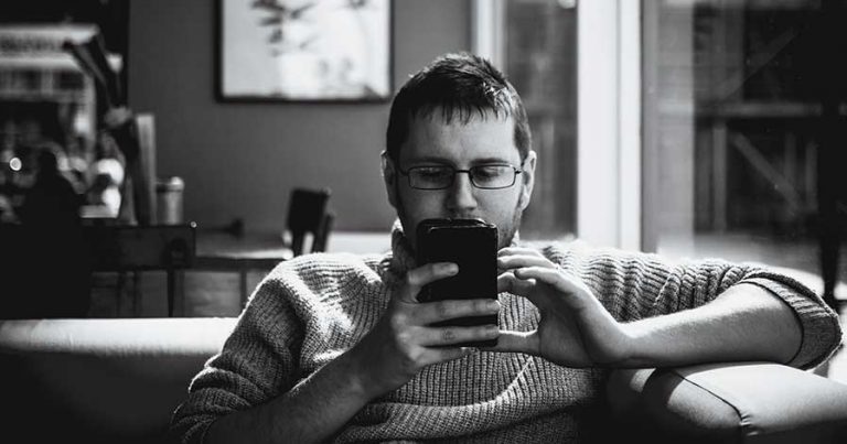 A man scrolling through his phone