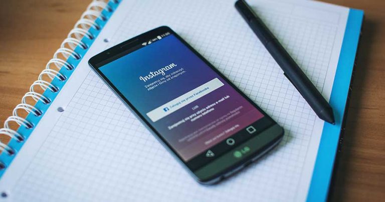 A cell phone laying on a table with the Instagram login page open