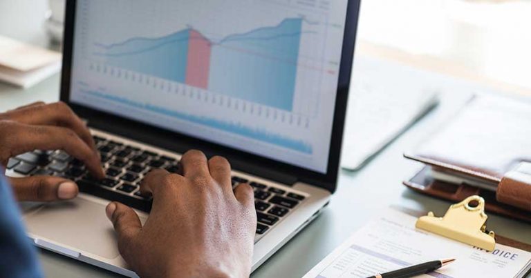 A man looking at graphs on a laptop