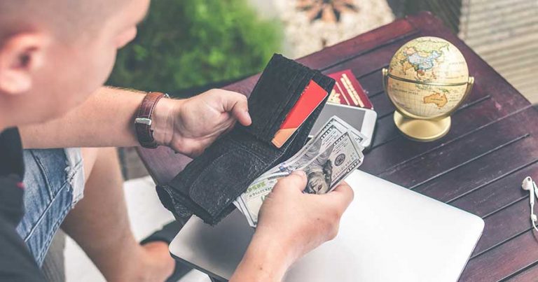 A man going through the contents of a wallet