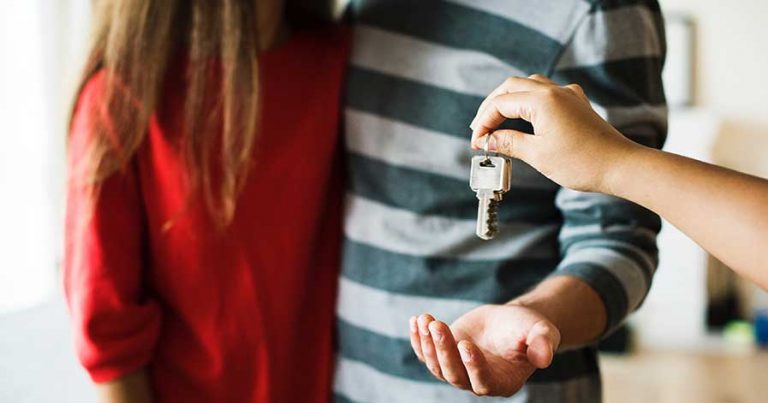 A couple being handed the key to a new home
