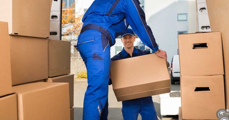 Two professional movers taking boxes out of a moving truck