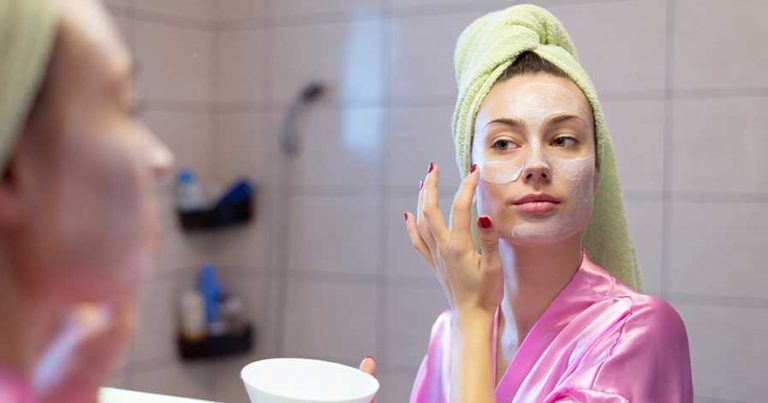 A woman applying night cream.