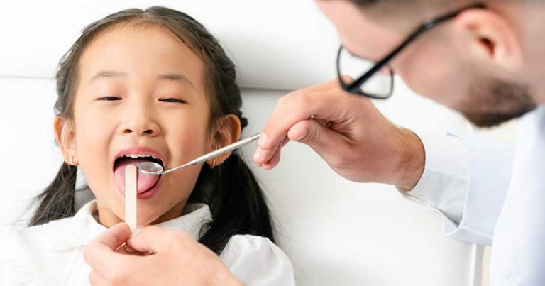 A young girl gets a checkup at the dentist
