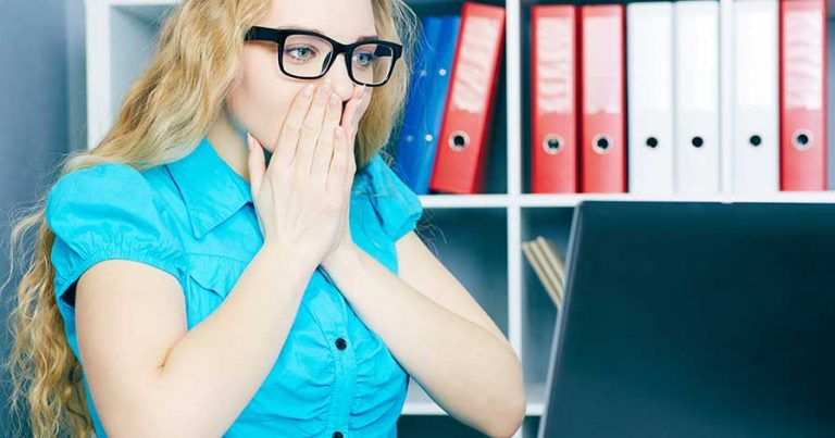 A stressed woman looking at a computer. She wants to know how to recover computer data.