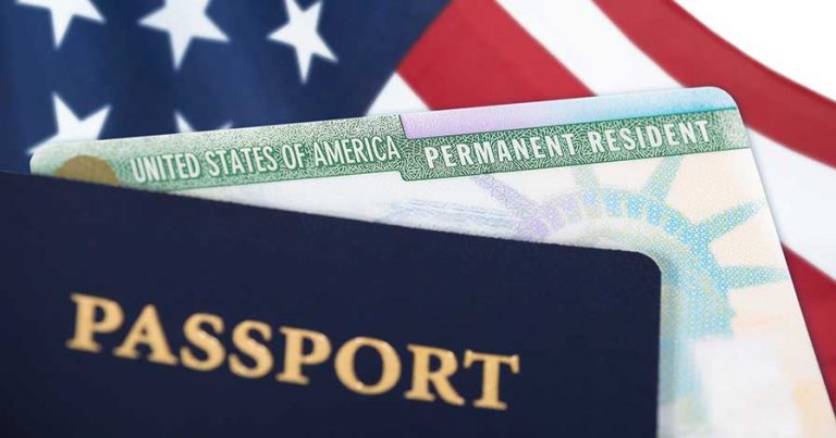 An American passport and green card on top of an American flag