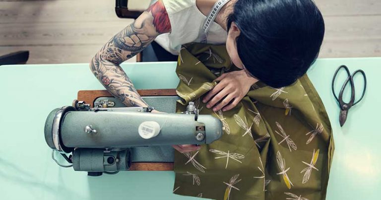 A woman using a sewing machine to make clothing