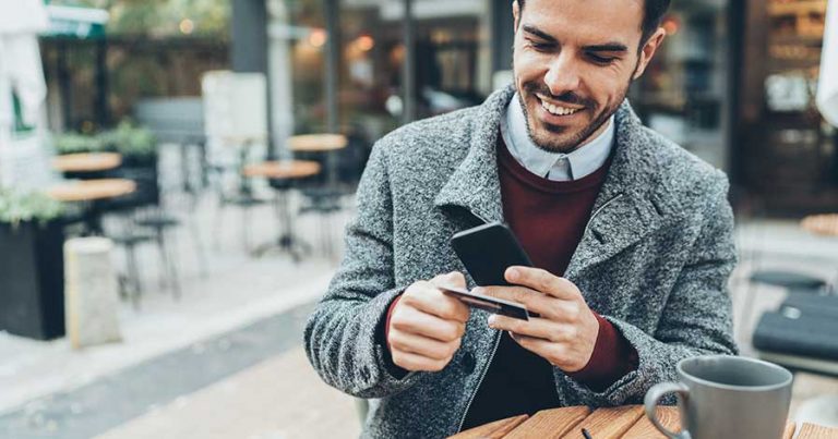 A man making a money transfer on his cell phone