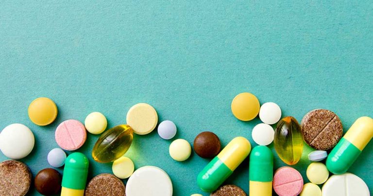Various vitamins and pills on a blue background