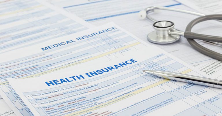 Medical insurance application, silver pen and stethoscope