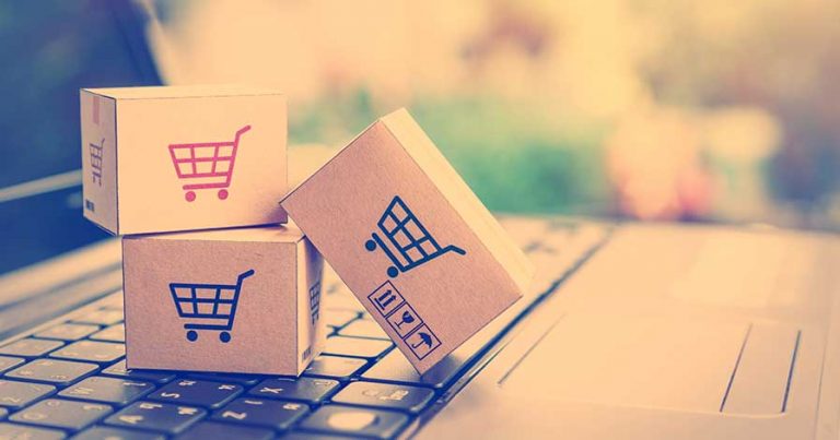 Small boxes with shopping carts on them, stacked on a laptop keyboard