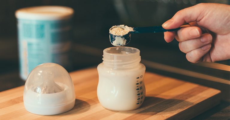 Someone adding formula to a bottle
