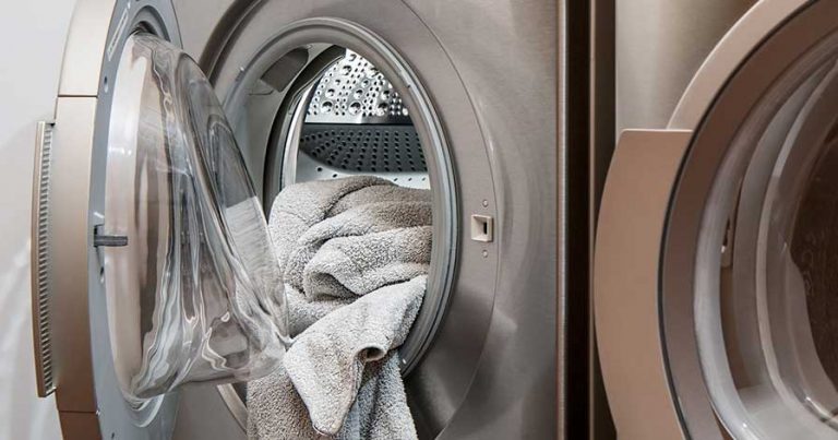 A washing machine filled with white towels