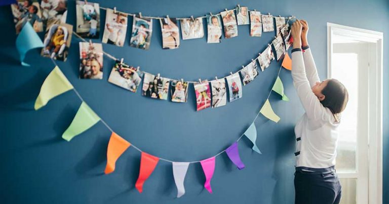 A woman hanging photo banners on a wall