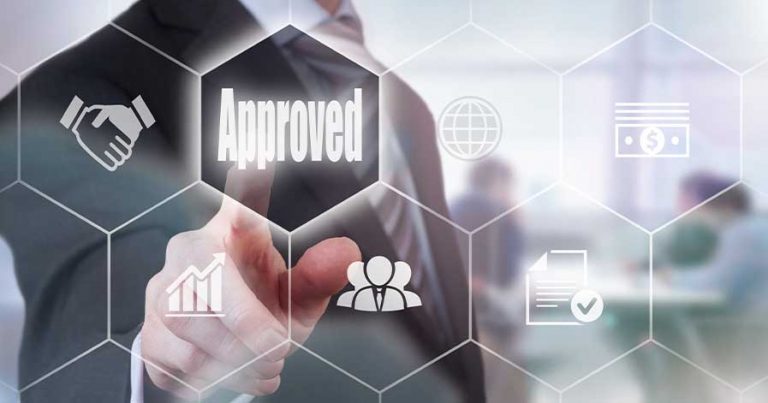 A man wearing a suit hitting a hexagon button that says "Approved."