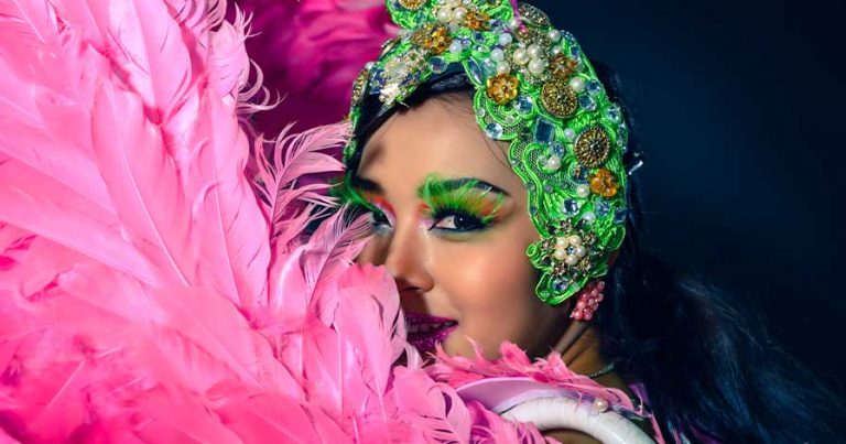 A woman wearing a pink, elaborate circus outfit.