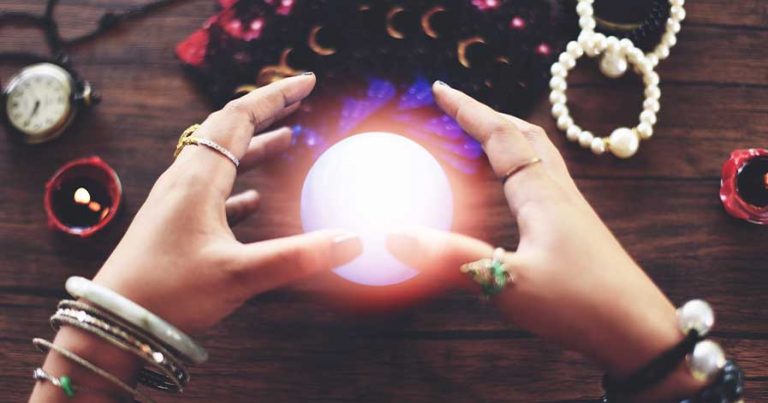 An orb between a person's hands. Around the orb is an assortment of bracelets.