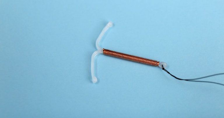 A copper IUD on a blue background